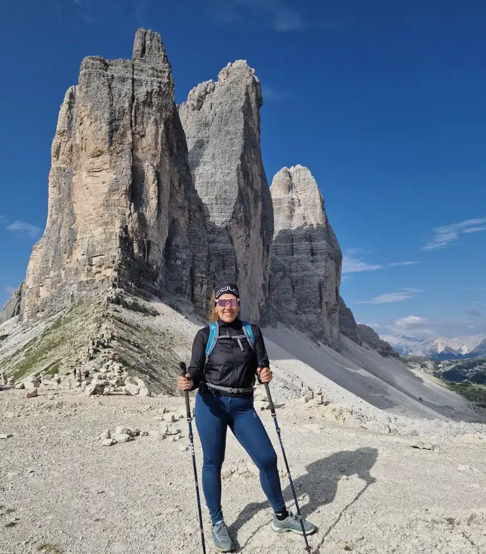 Ella Neff mit Wanderstöcken vor den Felsgipfeln der Drei Zinnen